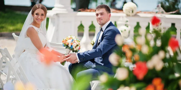 Mode et heureux couple de mariage assis sur cérémonie et hol — Photo