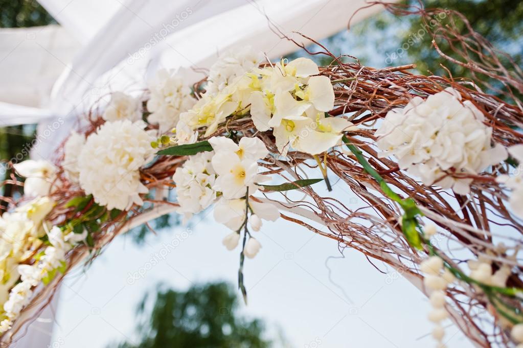 wedding arch with chairs and many flowers and decor