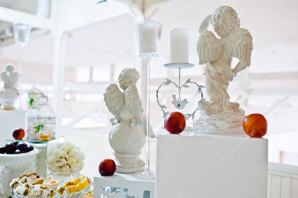 decorated figurines of angels and candles on wedding reception
