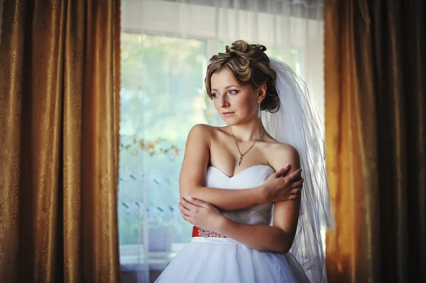 Young bride posing against the backdrop curtains — Stock Photo, Image