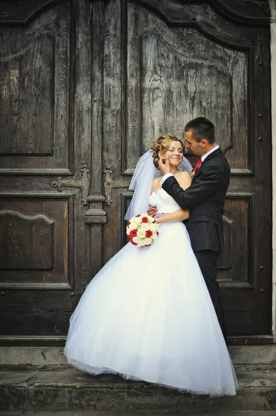 Casamento casal no fundo da velha porta de madeira — Fotografia de Stock