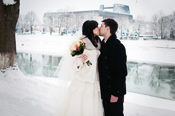 Svatební pár v zimě snowly pouliční pozadí studené řeky — Stock fotografie