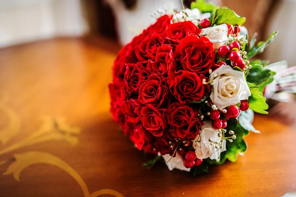 Ramo de boda rojo sobre mesa de madera — Foto de Stock