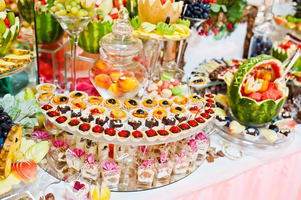 Svatební hostina. Stůl s ovocem a sladkostmi — Stock fotografie