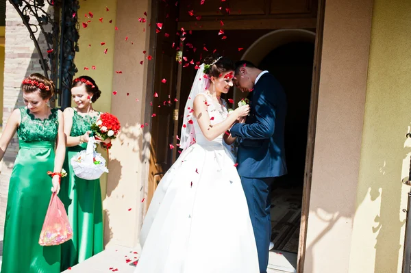 Casal de casamento em pétalas de rosas após a igreja reqistration — Fotografia de Stock