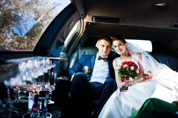 Hochzeitspaar in der Limousine — Stockfoto