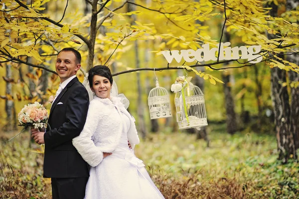 Casal de casamento feliz no dia de outono com sinal mrs & mr — Fotografia de Stock