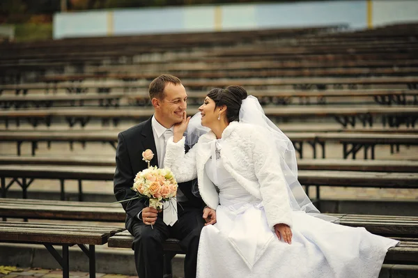 Wedding  couple sitting on many bench — Stock Photo, Image