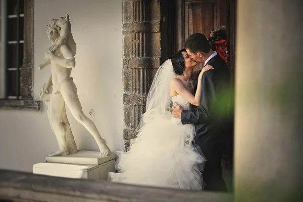 Embrasser couple de mariage près du monument de l'homme antique — Photo