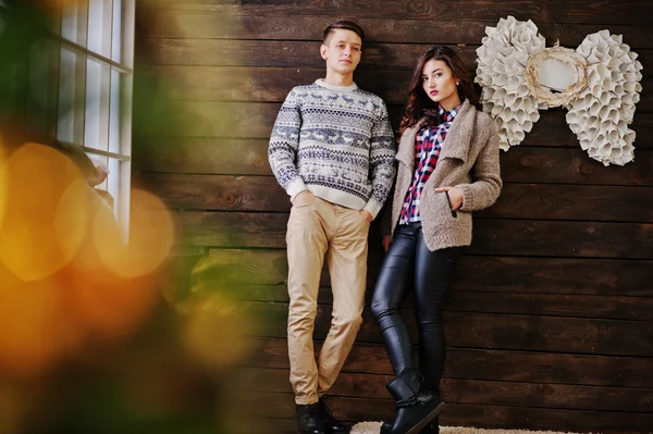 Young fashion winter  couple at wooden background
