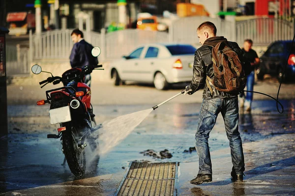 バイクのライダーが彼のオートバイを洗浄 — ストック写真