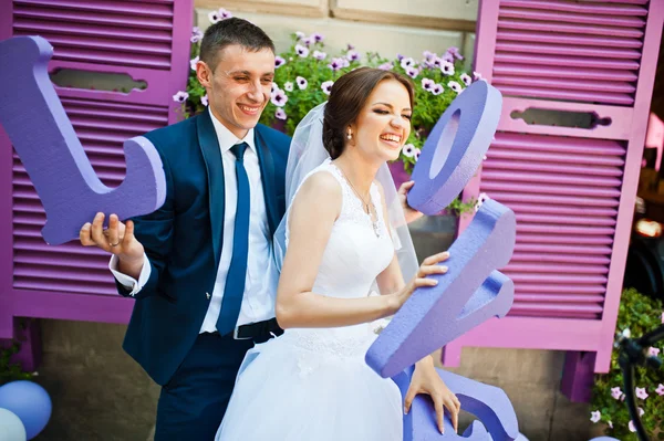 Newlywed with decor violet word love background purple wooden wi — Stock Photo, Image