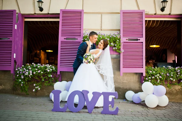 Newlywed with decor violet word love background purple wooden wi — Stock Photo, Image