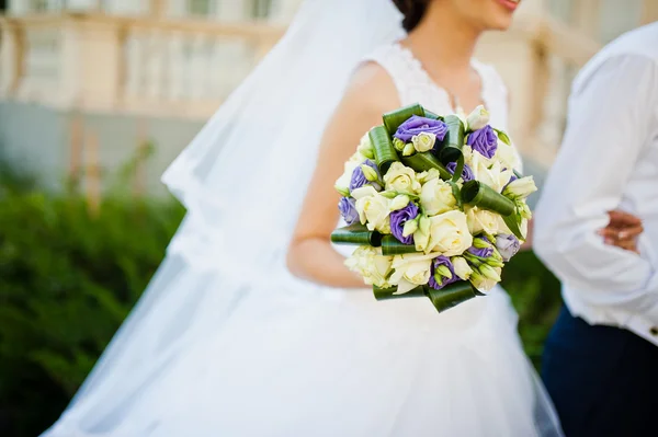 Ramo de boda violeta en la mano de la novia — Foto de Stock