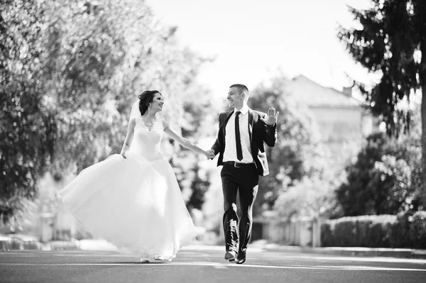 Correndo casal casamento feliz na estrada — Fotografia de Stock