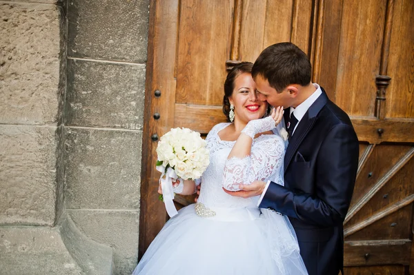 Pareja de boda cerca de la vieja puerta de madera de la iglesia católica —  Fotos de Stock