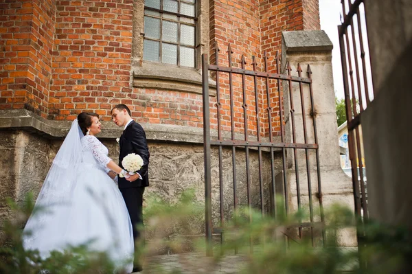 Coppia di matrimoni vicino alla vecchia porta di legno della chiesa cattolica — Foto Stock