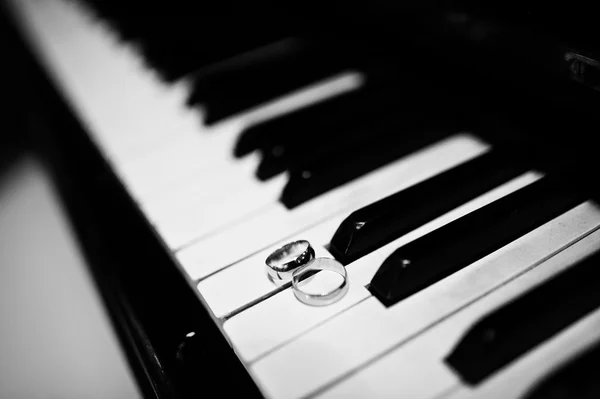 Anillos de boda en las teclas de piano, b & w foto —  Fotos de Stock