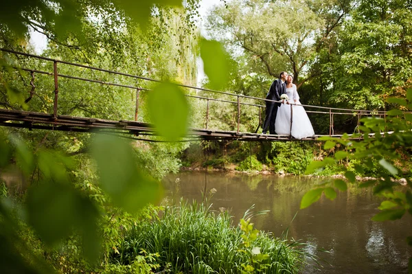 Enkel echtpaar op de hangbrug over de rivier — Stockfoto