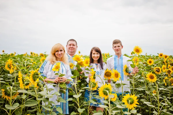 Happy family having fun on sunflowers — Stock Photo, Image