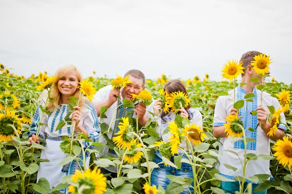 Happy family having fun on sunflowers — Stock Photo, Image