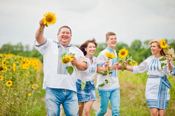 Happy family having fun on sunflowers — Stock Photo, Image