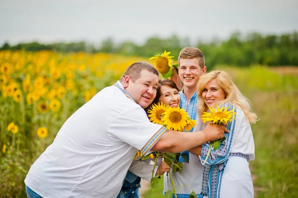Família feliz se divertindo em girassóis — Fotografia de Stock