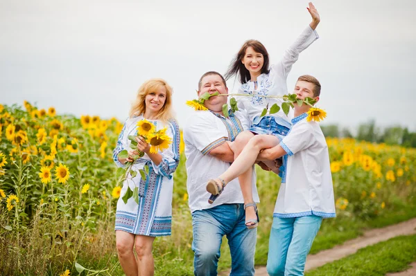Família feliz se divertindo em girassóis — Fotografia de Stock