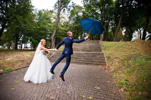 Legrační maried pár, ženich letu s deštníkem — Stock fotografie