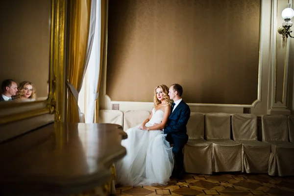 Schöne blonde Braut mit Bräutigam im großen Palast — Stockfoto