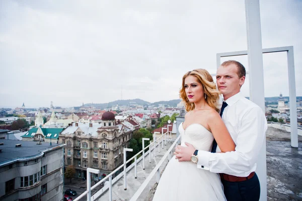 Элегантная свадебная пара на крыше с высокотехнологичной архитектурой — стоковое фото
