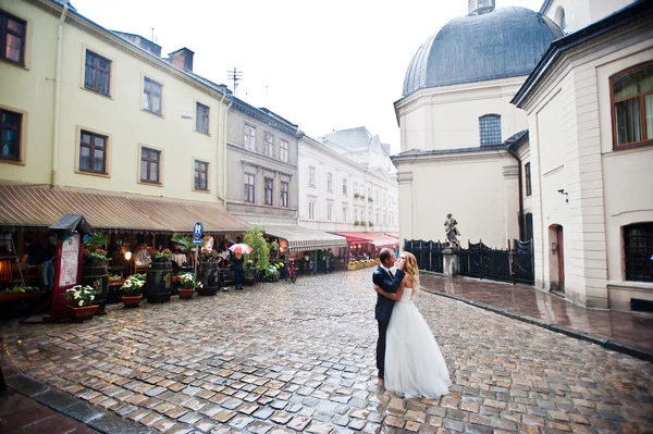 Matrimonio coppia sotto la pioggia nella città vecchia Lviv — Foto Stock