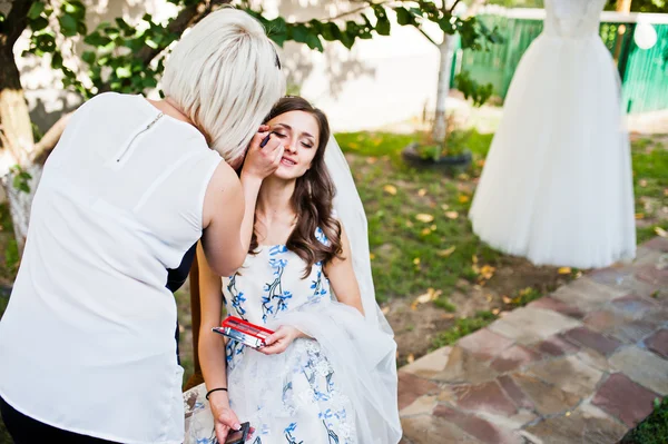 Master makeup artist doing makeup bride outdoors — Stock Photo, Image