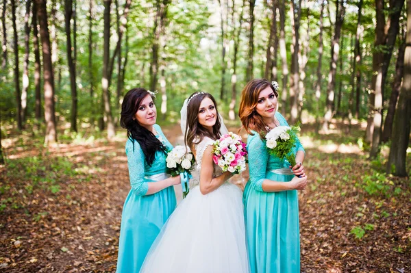 Novia con damas de honor en vestidos de turquesa al aire libre —  Fotos de Stock