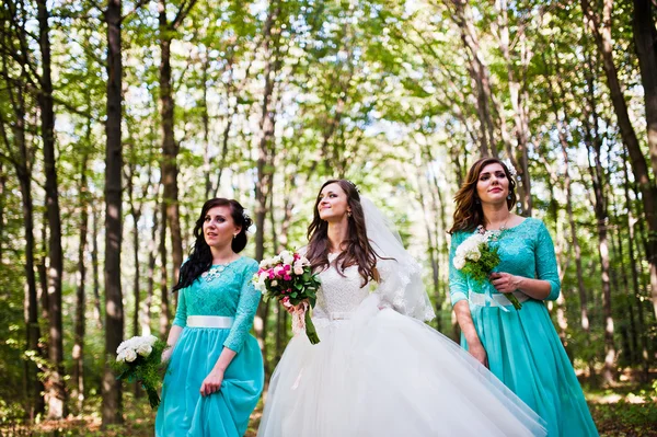 Noiva com damas de honra em vestidos de turquesa ao ar livre — Fotografia de Stock