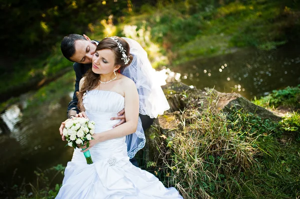 Hochzeitspaar sitzt am Stein im Herbstpark — Stockfoto