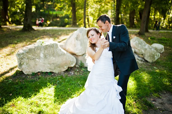 Dançando casamento casal ao ar livre fundo pedras grandes — Fotografia de Stock