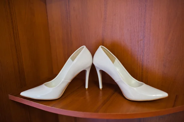 Zapatos de novia blancos sobre fondo de madera — Foto de Stock