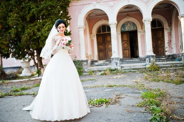 Elegáns barna menyasszony régi vintage rózsaszín ház oszlopokkal közelében — Stock Fotó