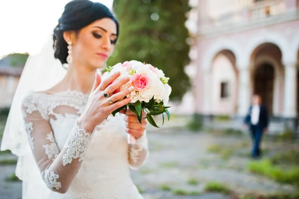 Стильная брюнетка невеста с букетом под рукой — стоковое фото