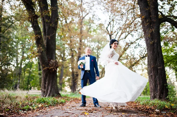 Elegante bruna sposa giocare con abito sul percorso autunnale — Foto Stock