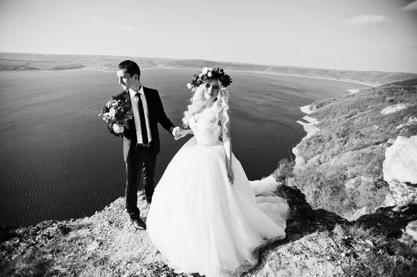 Charmante Braut im Kranz und eleganter Bräutigam auf Landschaften von — Stockfoto