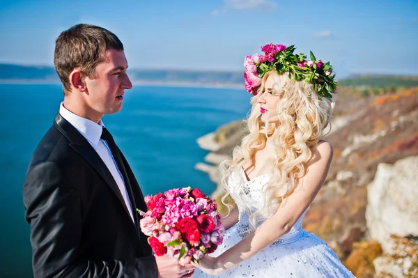 Charmante bruid in een krans en elegante bruidegom op landschappen van mo — Stockfoto