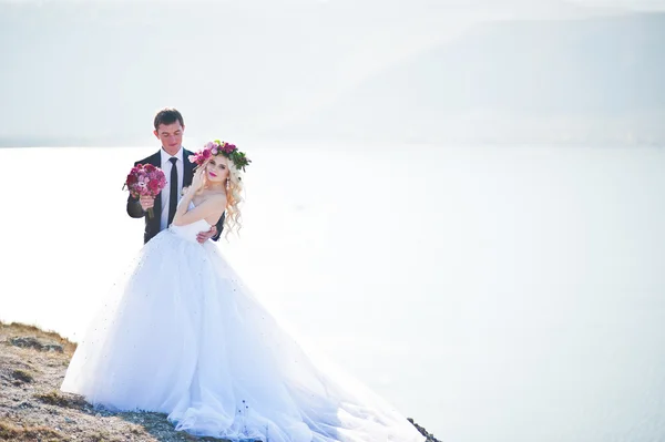 Noiva encantadora em uma grinalda e noivo elegante em paisagens de mo — Fotografia de Stock