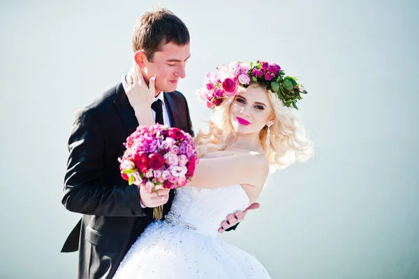 Bliska portret uroczej panny młodej w wieniec i eleganckie groo — Zdjęcie stockowe