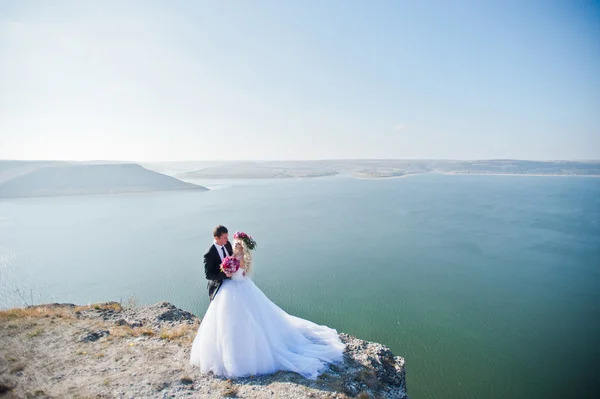 Encantadora novia en una corona y elegante novio en paisajes de mo — Foto de Stock