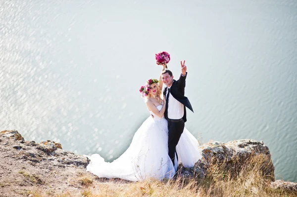 Charmig brud i en krans och eleganta brudgummen på landskapen i mo — Stockfoto