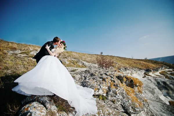 Sposa affascinante in una ghirlanda ed elegante sposo su paesaggi di mo — Foto Stock