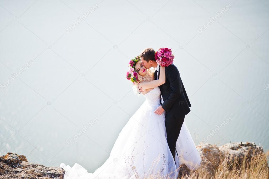 Charming bride in a wreath and elegant groom on landscapes of mo
