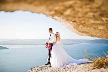 Charming bride and elegant groom on landscapes of mountains, wat